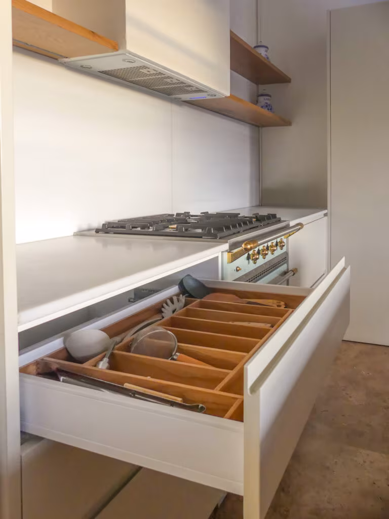 Kitchen drawer with timber cutlery tray beneath a pale worktop and gas hob in the La Vera cabin