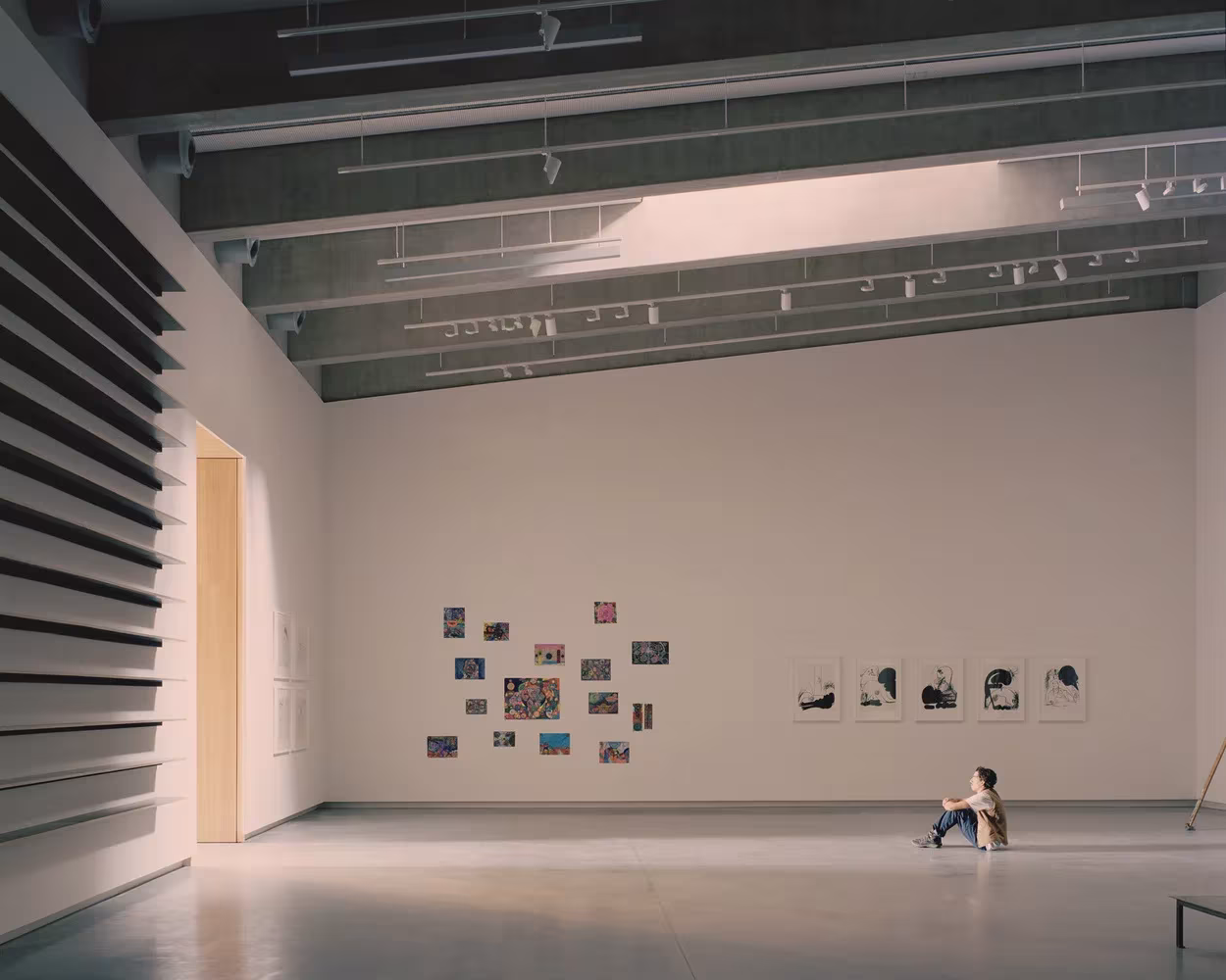 Sala de exposiciones de paredes blancas con vigas de acero y obras expuestas en el Bundanon Art Museum