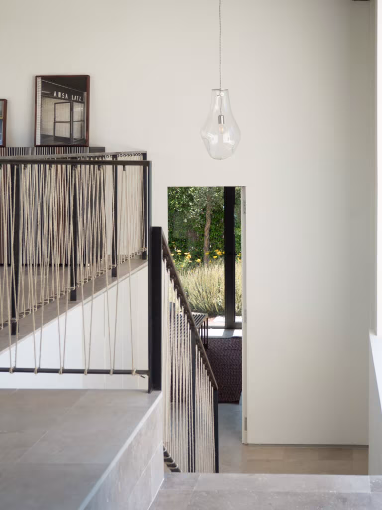 OLYMPUS DIGITAL CAMERA Stair with iron balustrade and blown-glass lamp descending to an entrance with garden views in Project PC