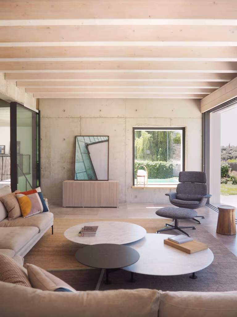 OLYMPUS DIGITAL CAMERA Living room with sofa, round coffee tables and a timber-beamed ceiling over concrete walls in Project PC by Ábaton