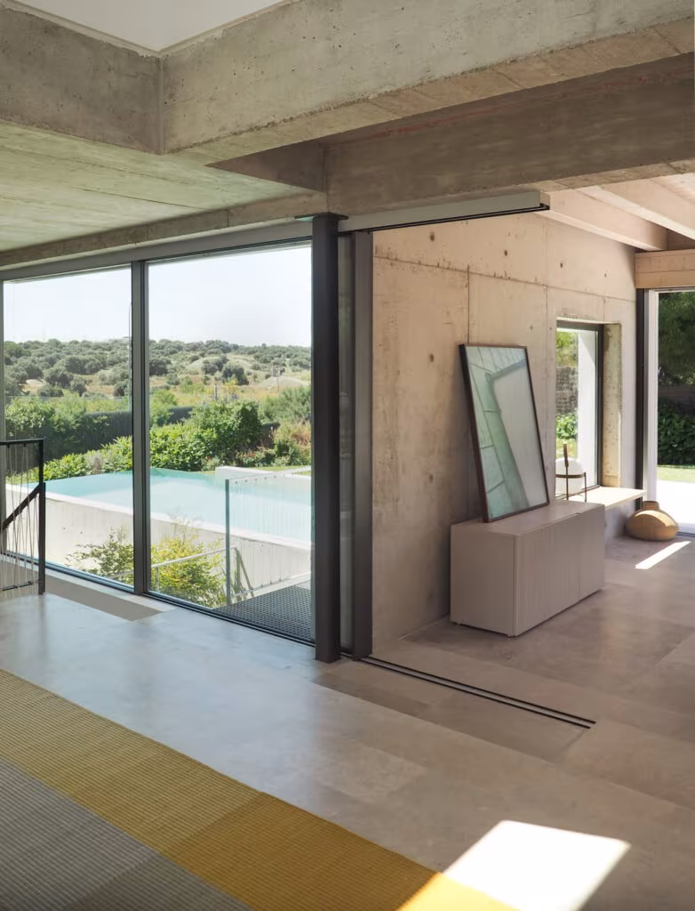 OLYMPUS DIGITAL CAMERA Large window over the pool and landscape from a concrete and stone hall with a yellow rug in Project PC