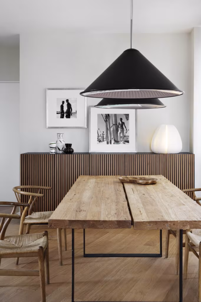 Dining room with plank table, rush chairs, slatted sideboard and black pendant in Rosales