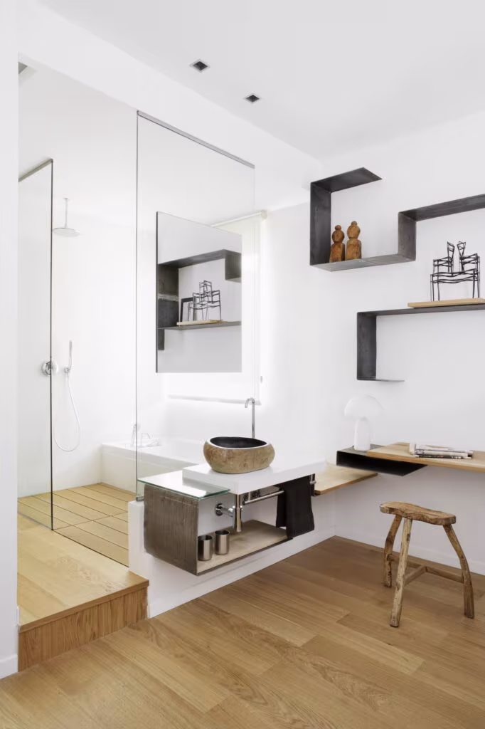 Suspended stone basin, steel shelves and mirror in the bathroom within the bedroom in Rosales