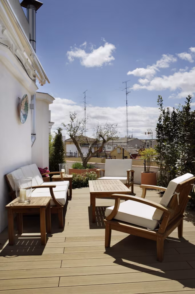 Terrace with timber decking, outdoor sofas and a city view in the Rosales full refurbishment