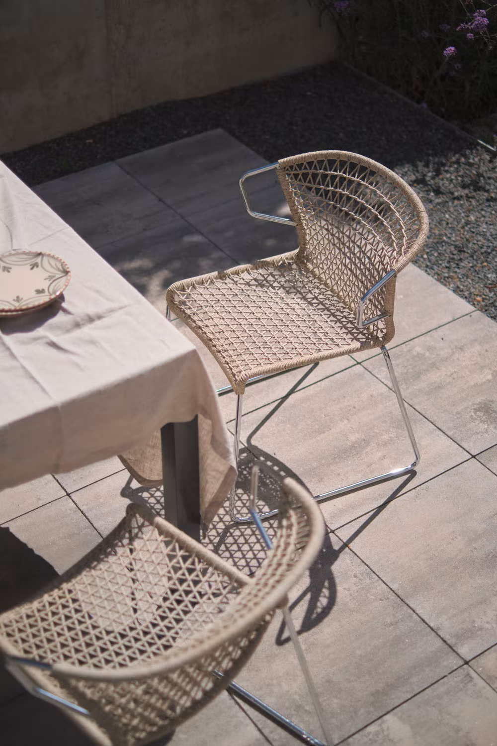 Abaton – Pozuelo 24 Woven rope chairs beside the table on the concrete and gravel terrace of Project PC