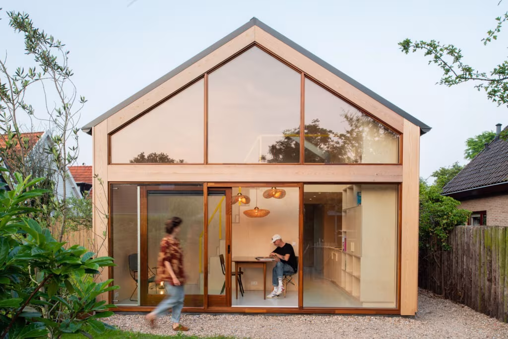 Garden Studio de Studio Abacaxi, casa de frontón de dos aguas con fachada acristalada y marco de madera, en Holanda