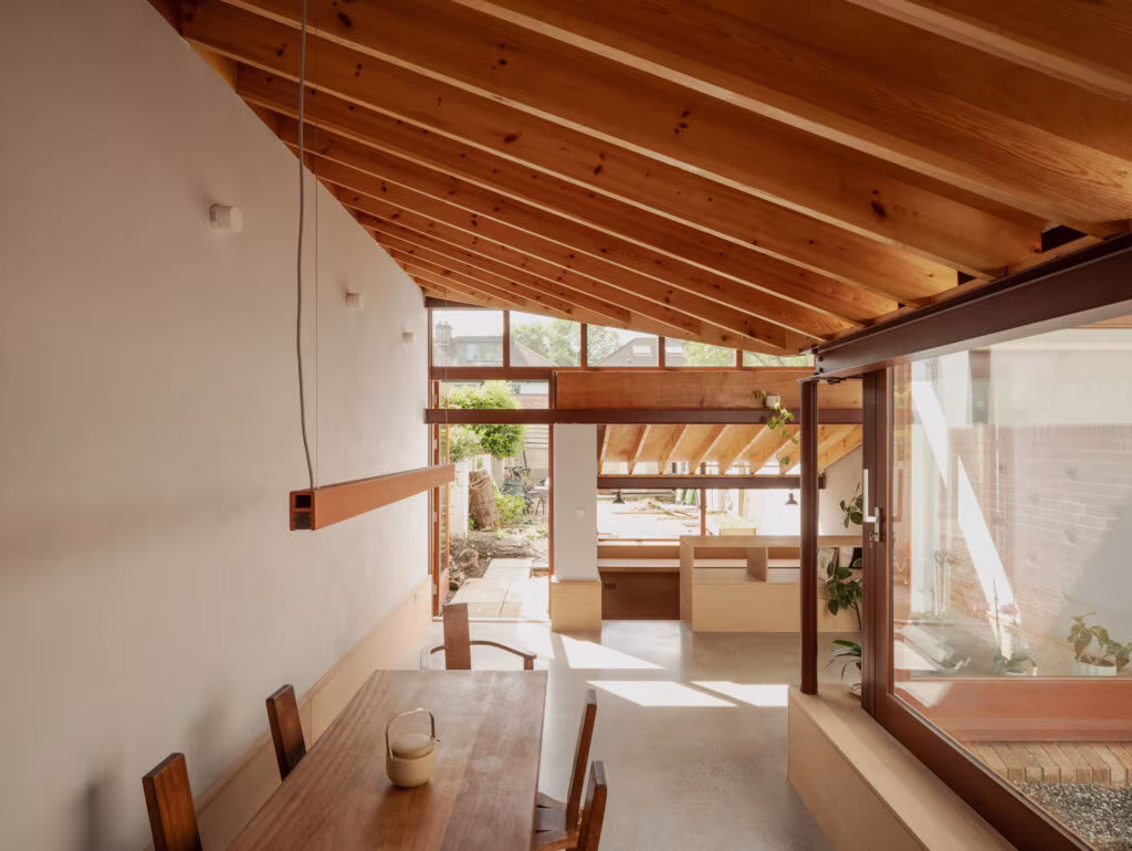 Cocina-comedor bajo cubierta de vigas de pino que se abre al jardín en la reforma Birdhide, Irlanda
