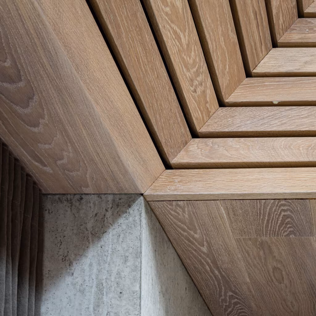 Detail of the junction between the oak ceiling planks and the concrete wall in the Cluster House
