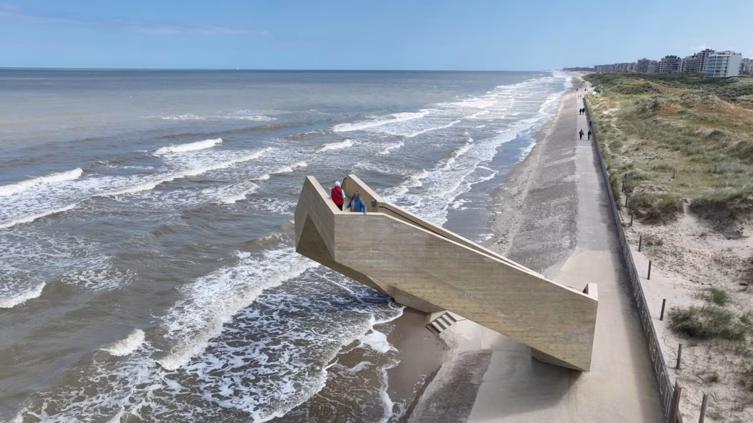 Vista aérea de Westerpunt sobre la orilla con oleaje y dunas junto a los edificios de De Panne