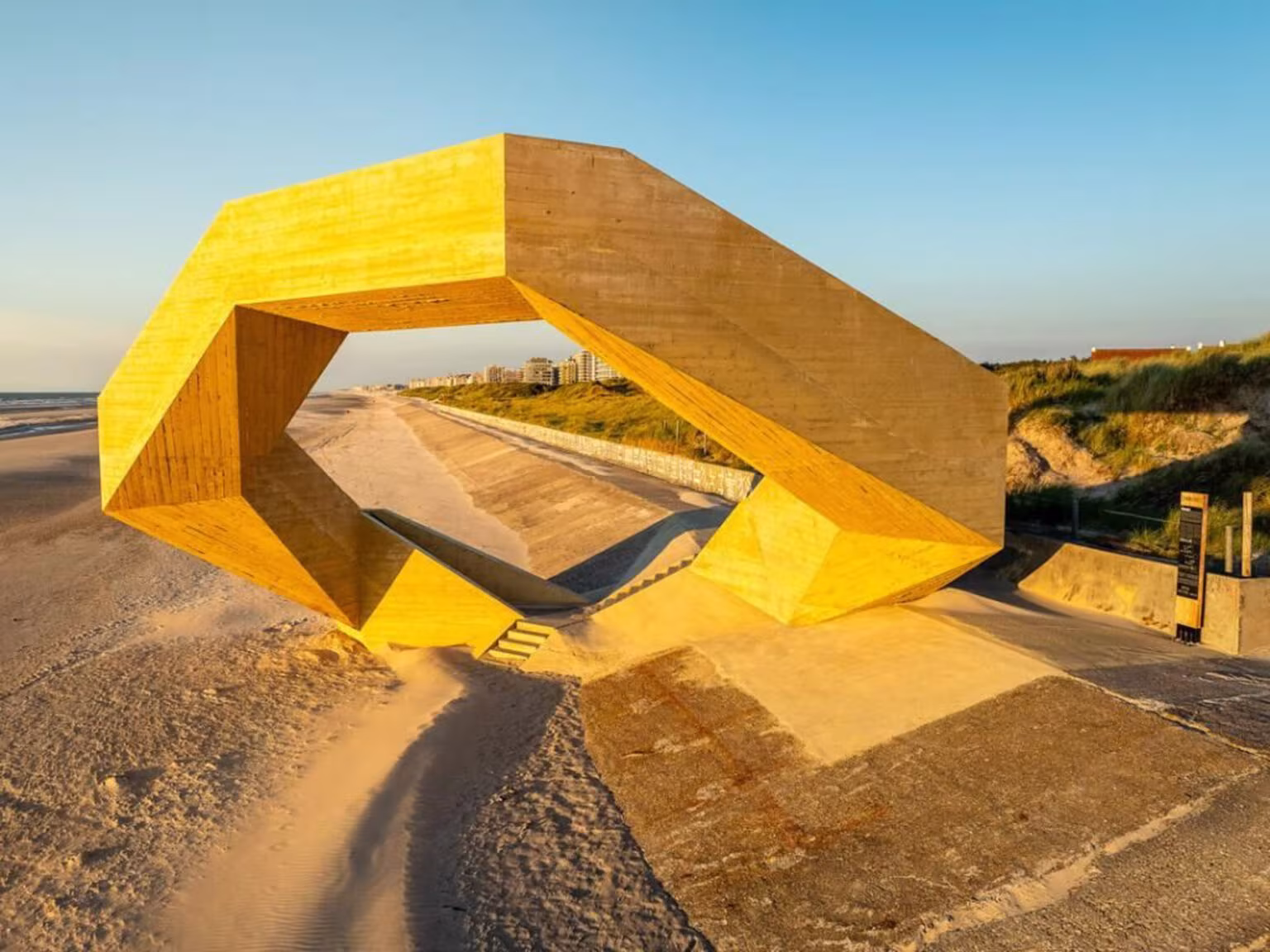 Westerpunt iluminado por la luz dorada del atardecer sobre el dique, con sus facetas de hormigón