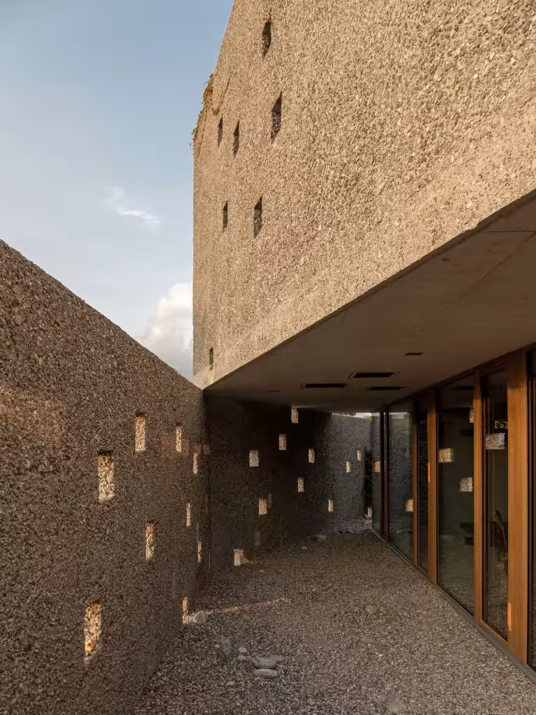 Pasaje estrecho entre muros de piedra con huecos de luz que conduce a la entrada de San Nazzaro