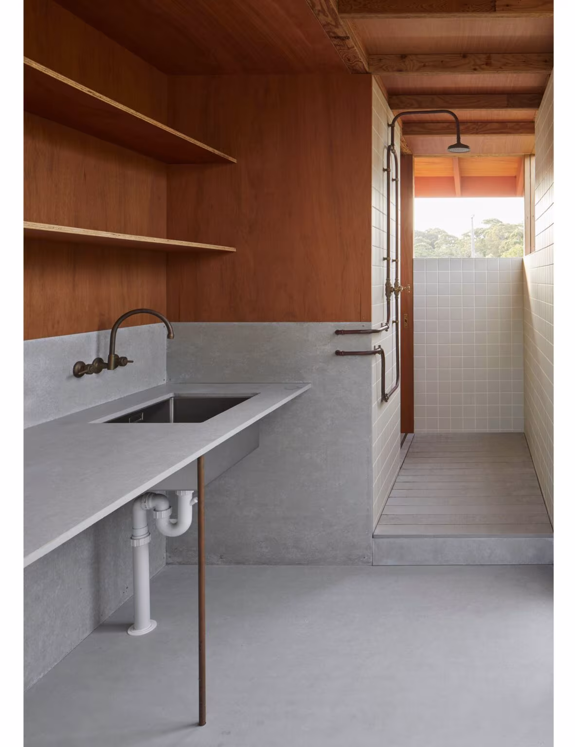 Baño de Princes Studio con encimera y fregadero de hormigón claro, estantes de madera y ducha exterior