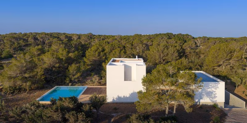 ses-clotades-02 Vista aérea de Ses Clotades, casa blanca con piscina azul en medio del pinar mediterráneo